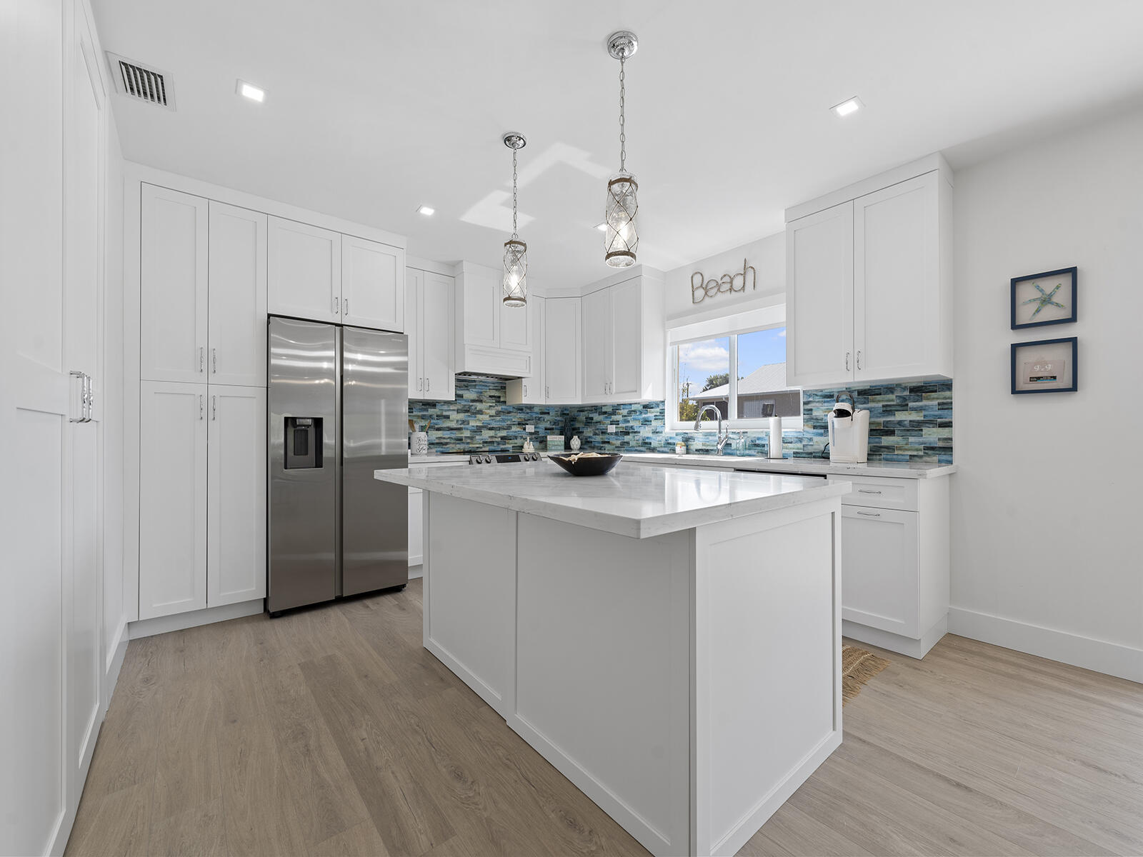22 Atlantic Boulevard, Unit B Key Largo, FL 33037 - Photo 13 of 50 a kitchen with kitchen island white cabinets and refrigerator