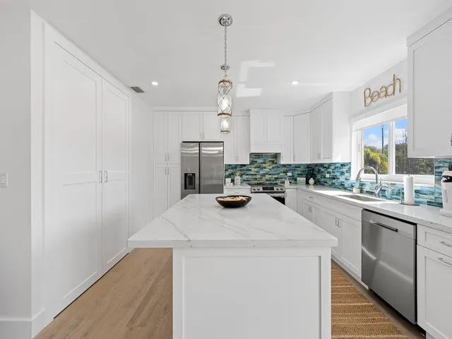 a kitchen with a sink a stove and cabinets