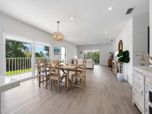 a view of a dining room and livingroom with furniture wooden floor a chandelier