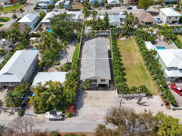 an aerial view of residential houses with outdoor space and lake view