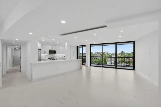 a large white kitchen with a large window and stainless steel appliances