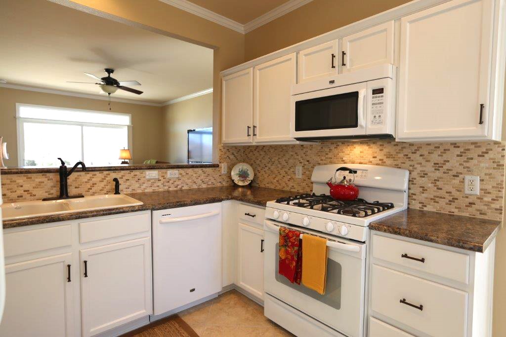 109 Ranier Lane Georgetown, TX 78633 - Photo 4 of 18 White cabinetry, an eat-in kitchen, and mosaic tile backsplash make this space perfect for entertaining.