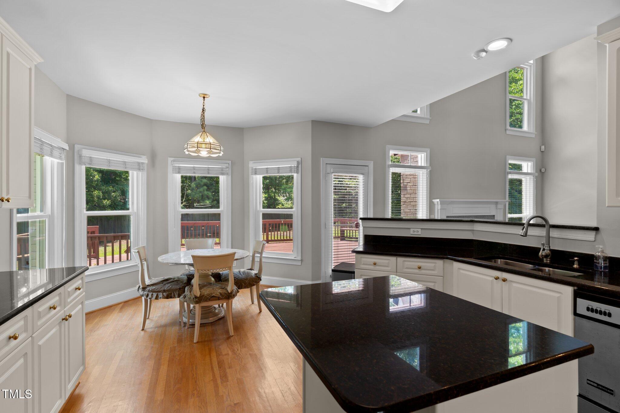 3556 Iris Street Wilmington, NC 28409 - Photo 14 of 52 a kitchen with stainless steel appliances granite countertop a sink a stove and a wooden floors