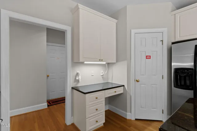 a kitchen with granite countertop white cabinets and white appliances