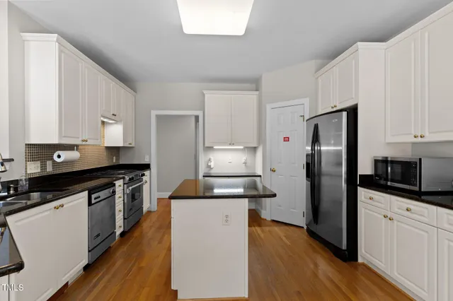 a kitchen with white cabinets and white appliances