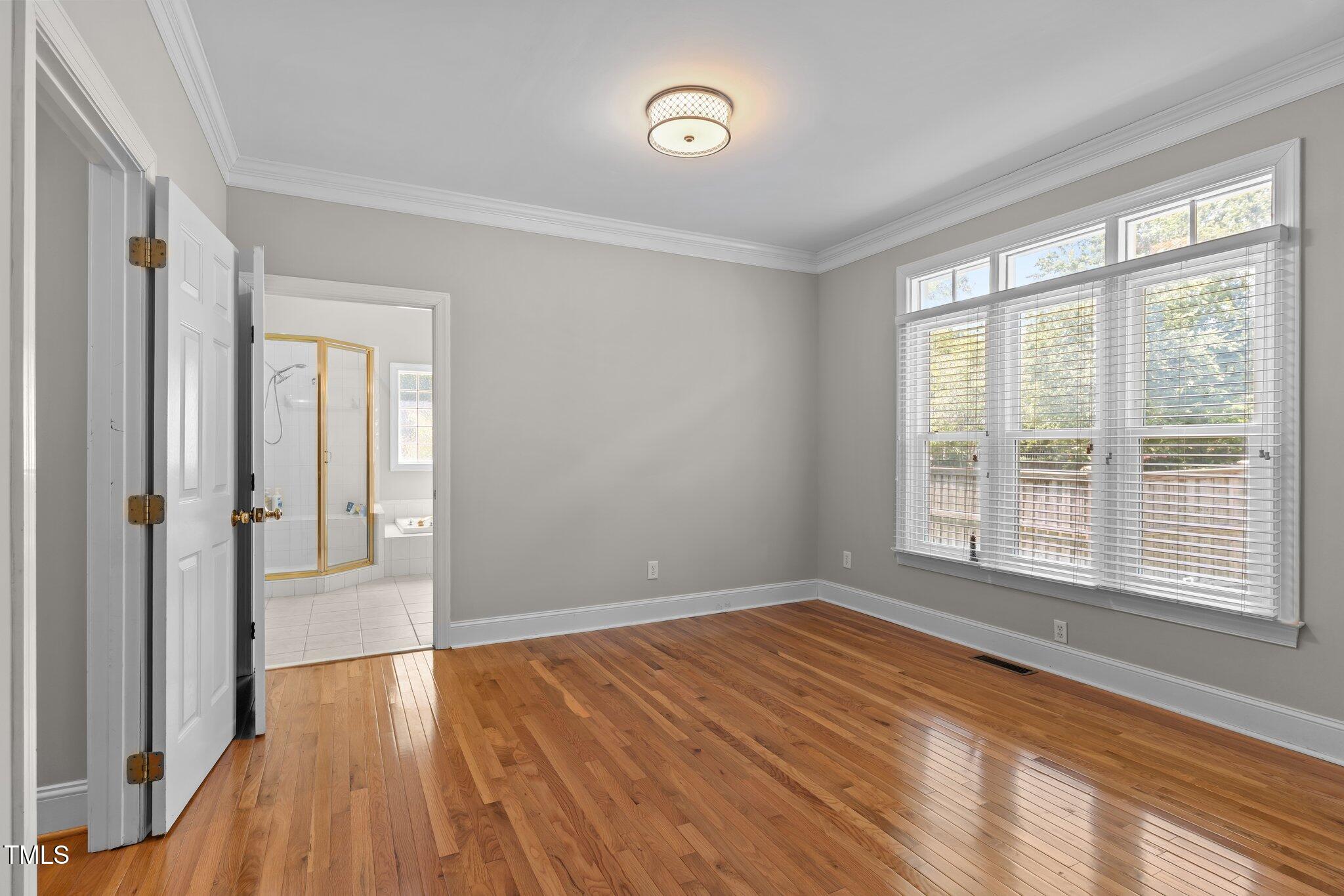 3556 Iris Street Wilmington, NC 28409 - Photo 25 of 52 a view of an empty room with wooden floor and a window