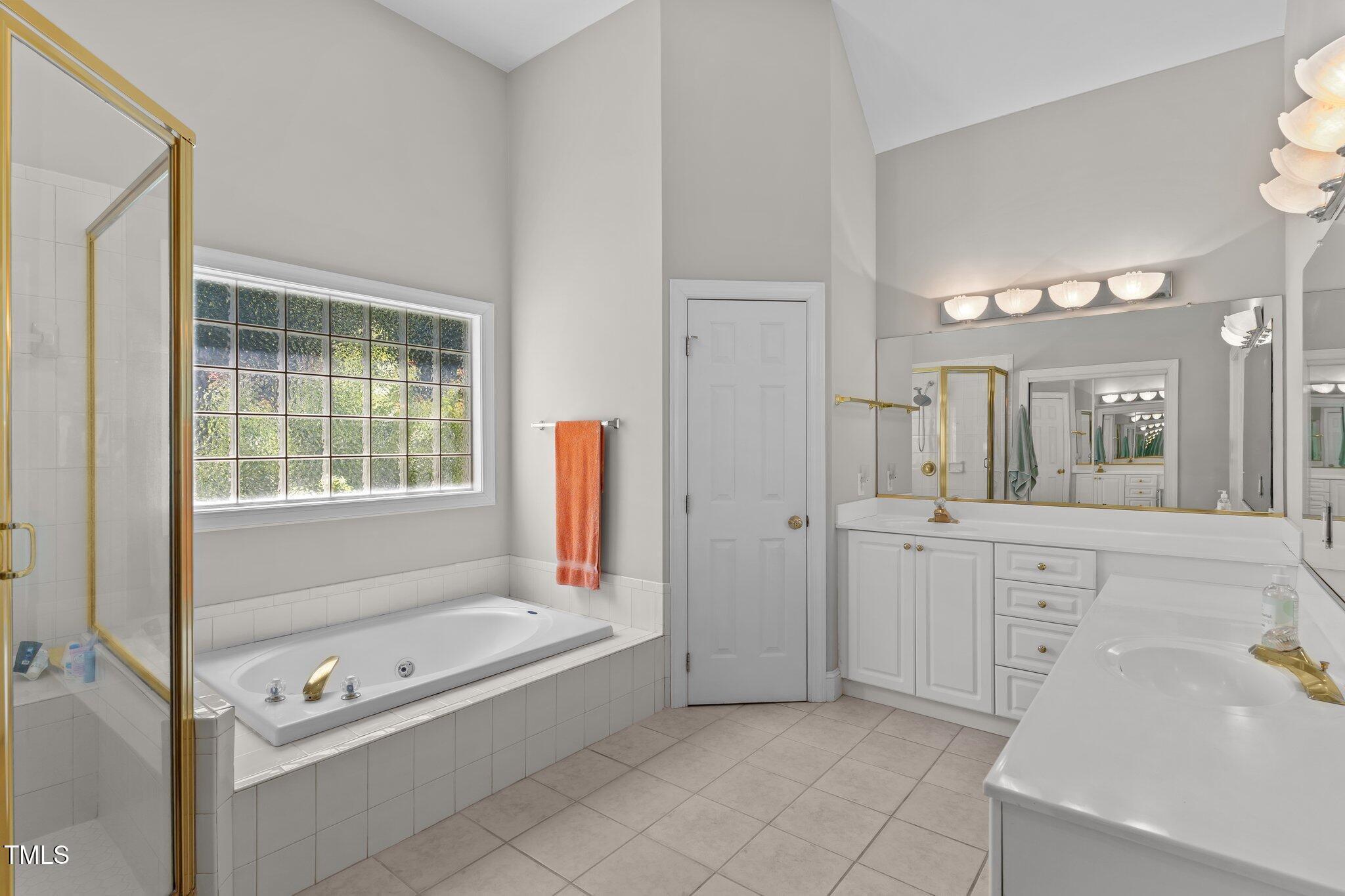 3556 Iris Street Wilmington, NC 28409 - Photo 26 of 52 a bathroom with a tub a sink and a window