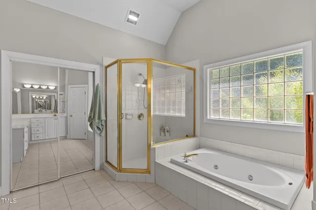 a bathroom with a tub a sink and a window