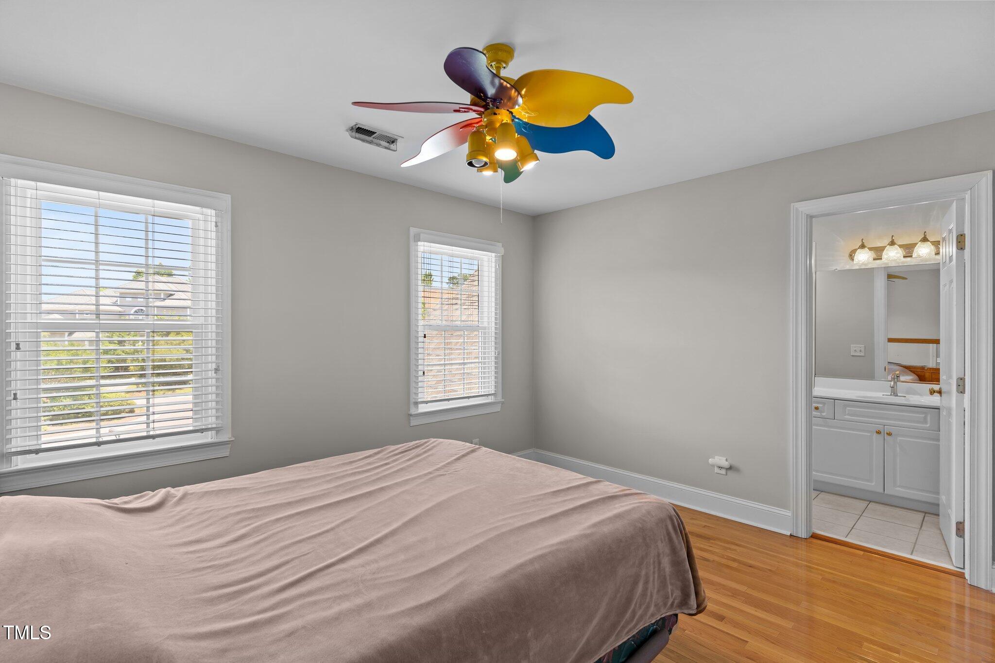 3556 Iris Street Wilmington, NC 28409 - Photo 31 of 52 a bedroom with a bed a dresser and chandelier