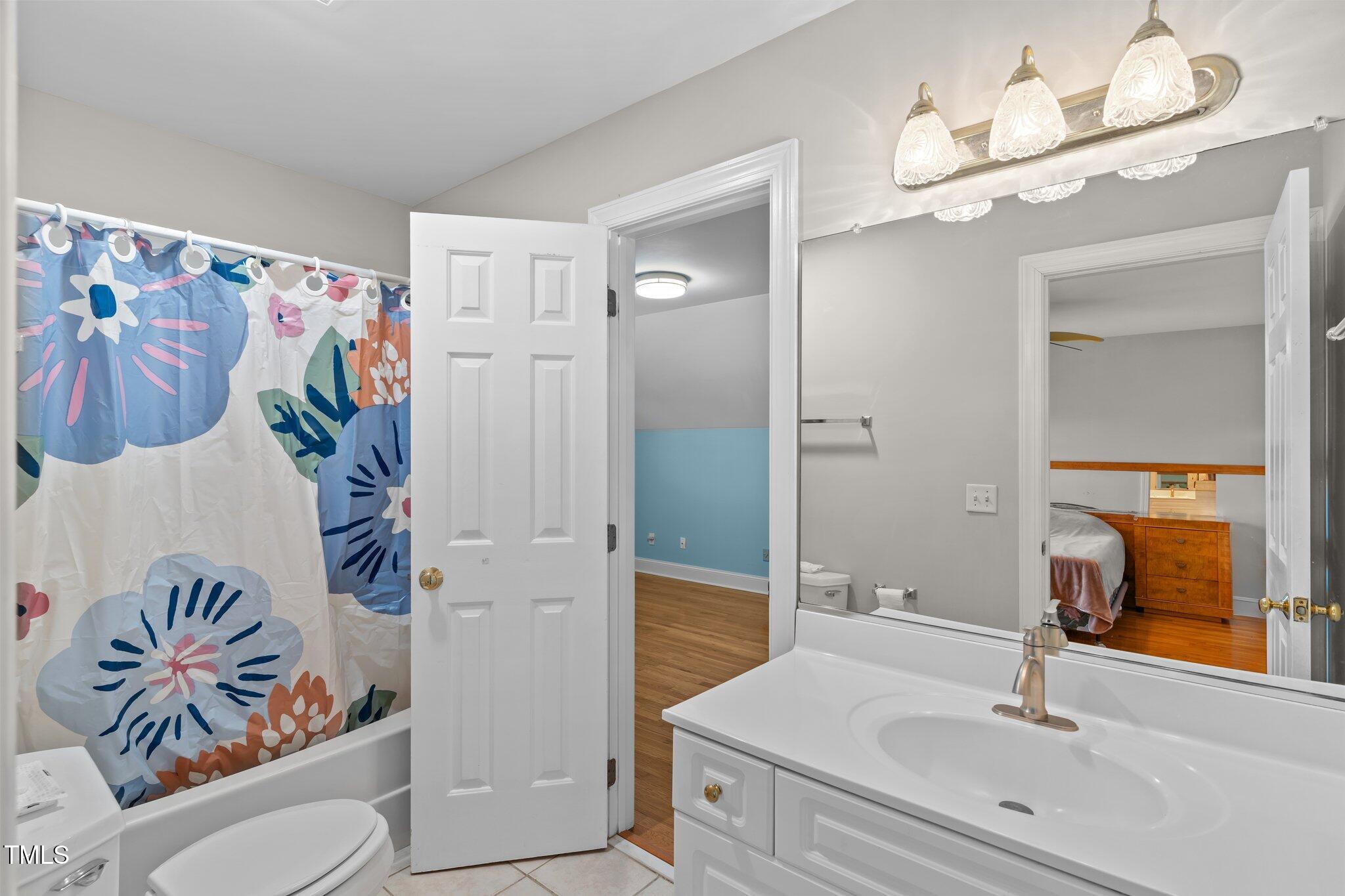 3556 Iris Street Wilmington, NC 28409 - Photo 32 of 52 a bathroom with a sink a toilet and a mirror