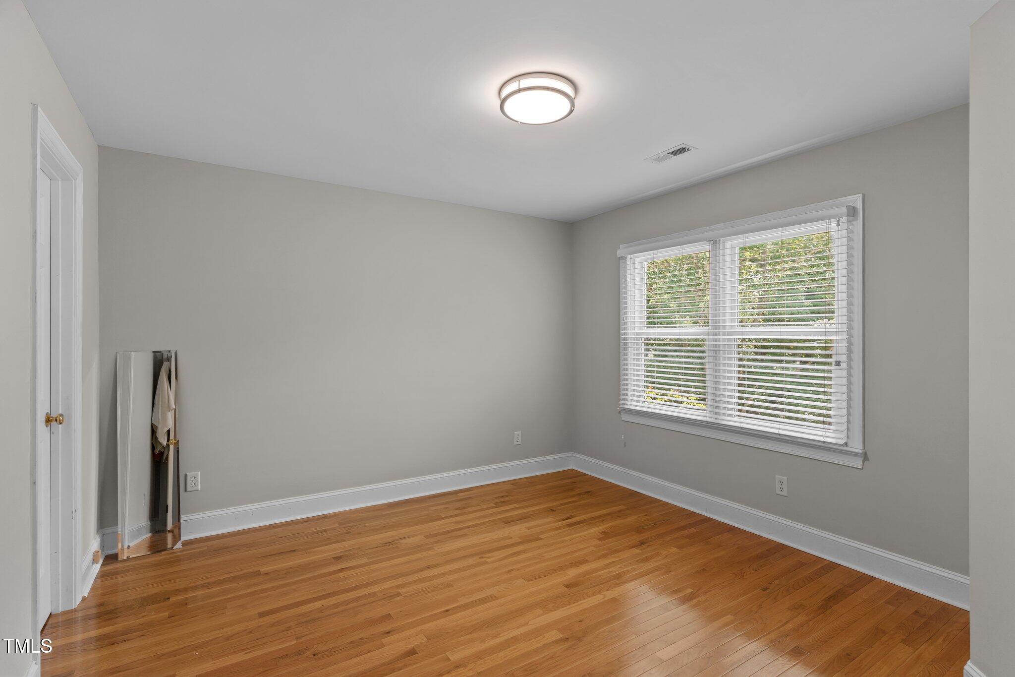 3556 Iris Street Wilmington, NC 28409 - Photo 35 of 52 a view of an empty room with wooden floor and a window
