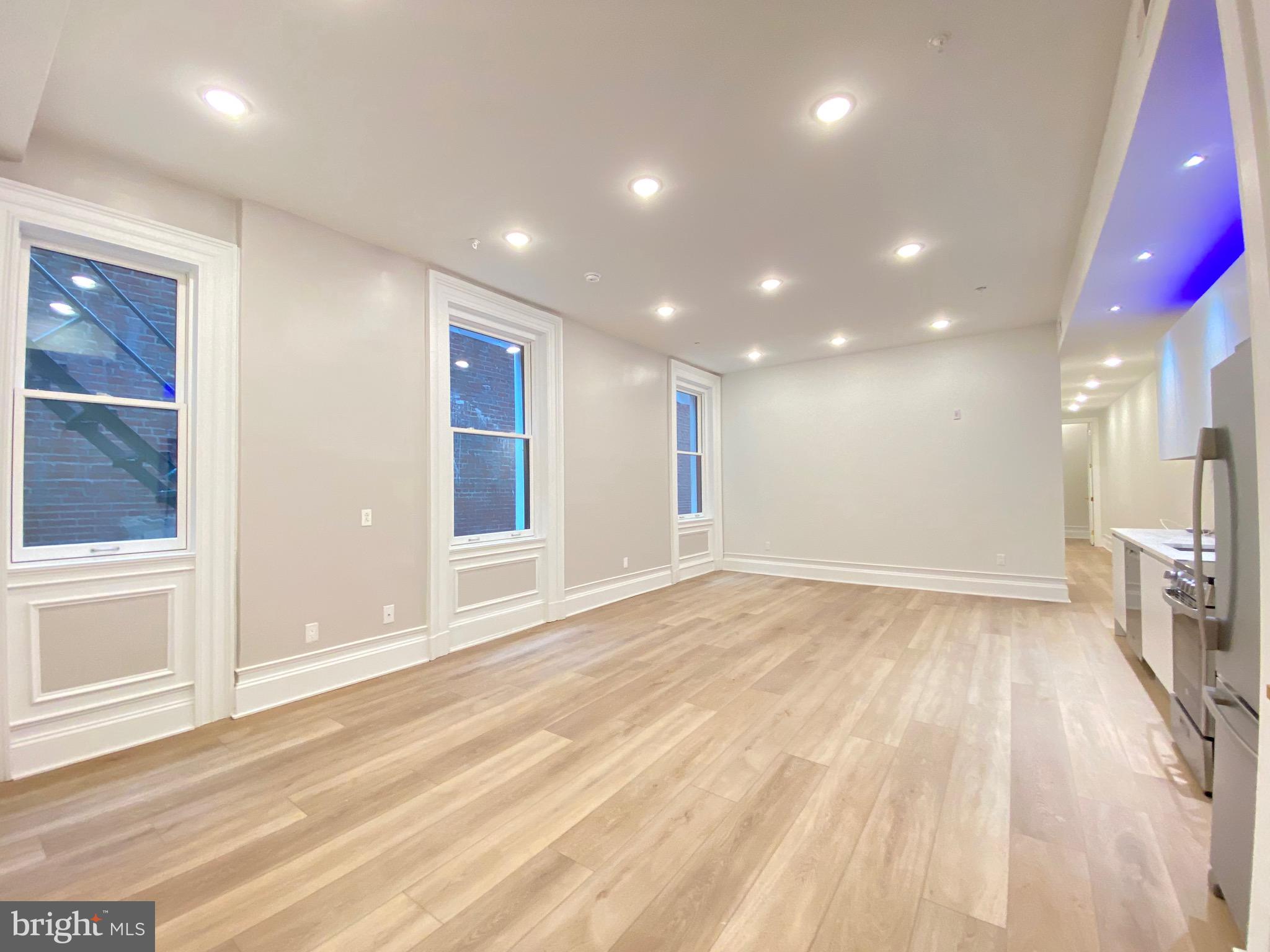 1824 Chestnut Street, Unit 1R Philadelphia, PA 19103 - Photo 2 of 12 a view of empty room with wooden floor and fan