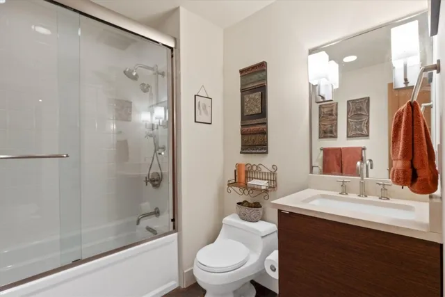 a bedroom with a bed and dresser with wooden floor