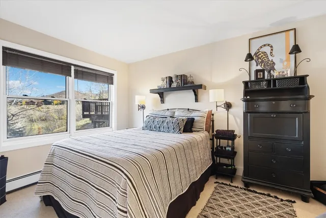 a bedroom with a bed and a lamp on dresser