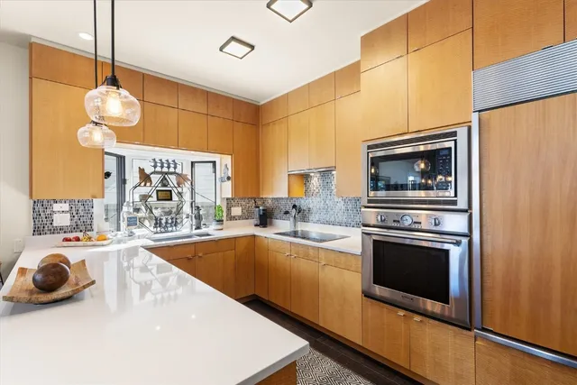 a dining room with wooden floor a chandelier a wooden table and chairs