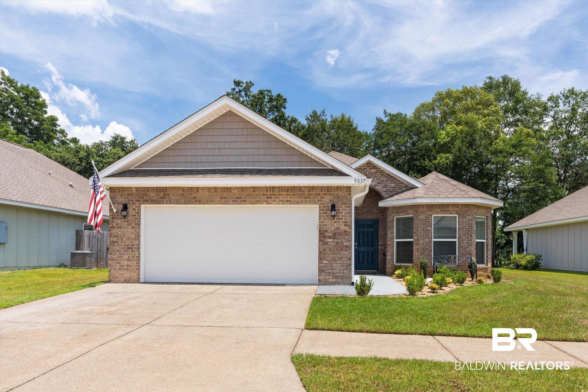 Single story home featuring brick siding, concrete driveway, a front yard, and a garage