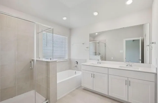 a bathroom with a tub a sink and mirror