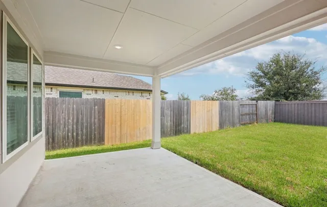 a view of a backyard with wooden fence