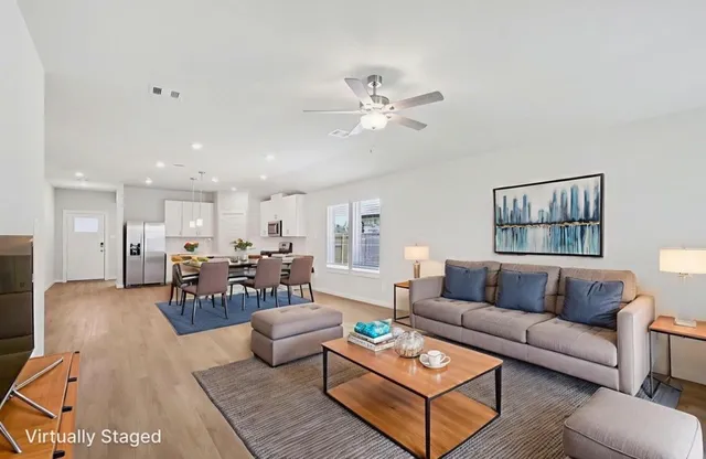 a living room with furniture kitchen view and a window