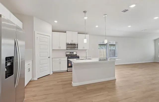 a kitchen with stainless steel appliances kitchen island a refrigerator a stove a sink and a oven