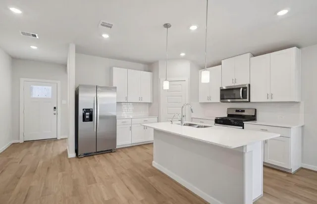 a kitchen with stainless steel appliances a refrigerator stove microwave and cabinets