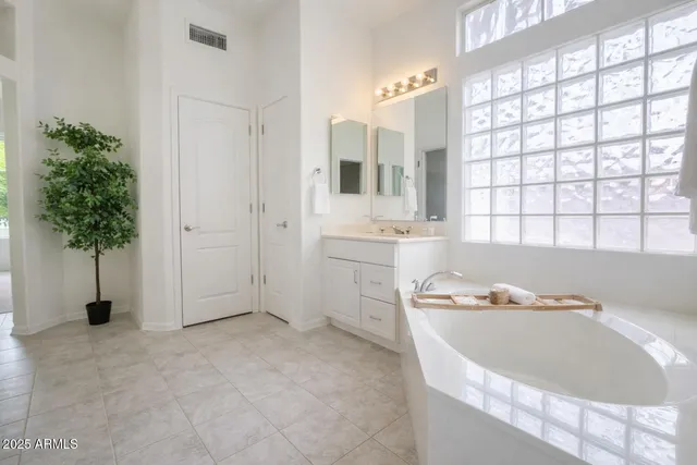 a bathroom with a tub a sink and a window