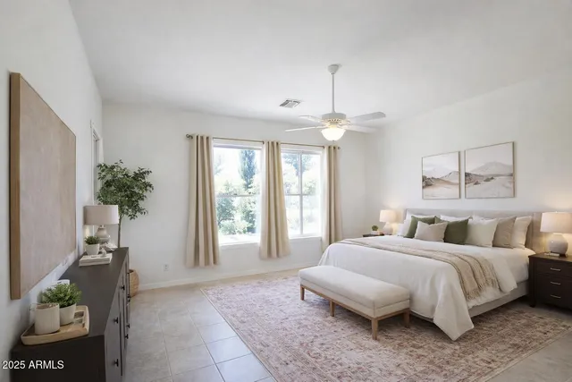 a spacious bedroom with a bed and a potted plant