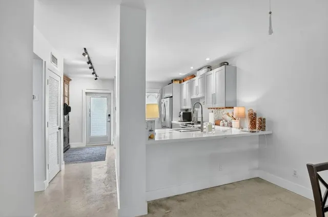 a view of a kitchen with kitchen island and stainless steel appliances