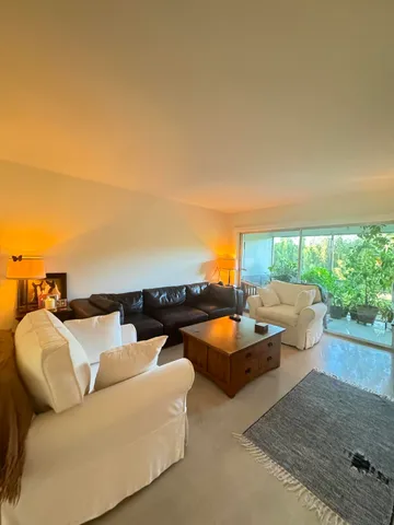 an outdoor living room with furniture and a flat screen tv