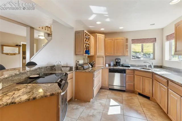 a kitchen with stainless steel appliances granite countertop a refrigerator and a sink