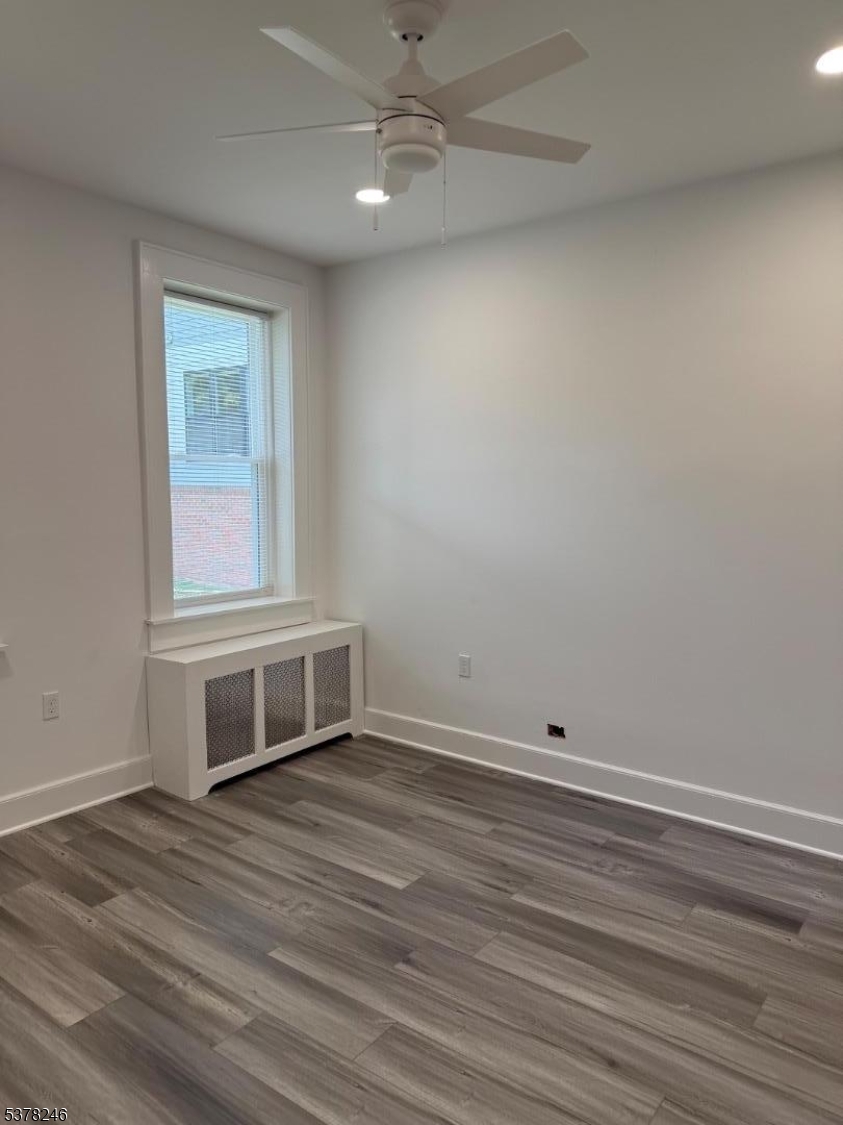 22 Baldwin Street, Unit 2 Montclair, NJ 07042 - Photo 11 of 20 an empty room with wooden floor cabinet and windows