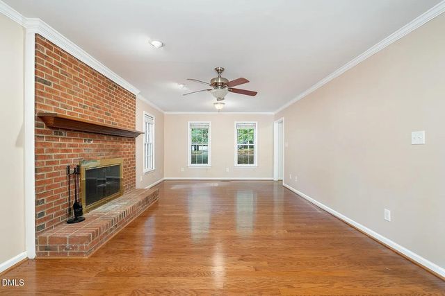 a view of an empty room with a fireplace and a window
