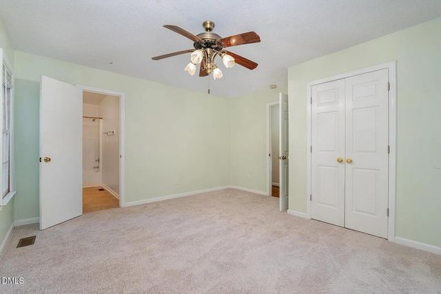 an empty room and chandelier fan