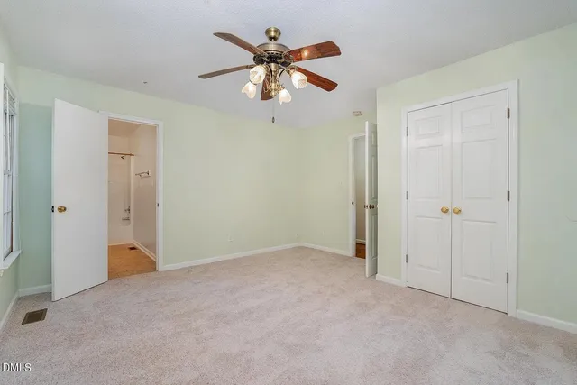 an empty room and chandelier fan