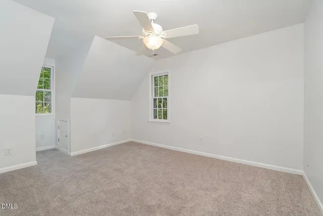 an empty room with windows and ceiling fan