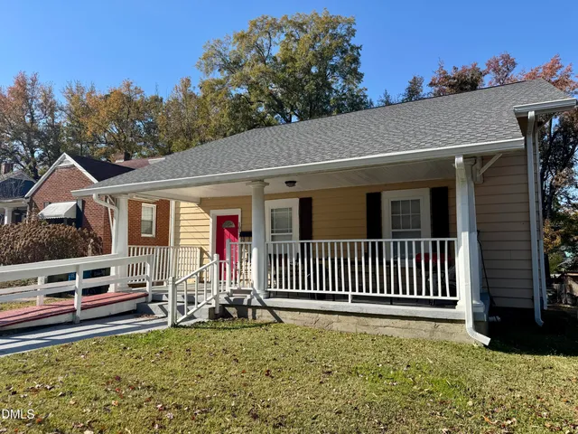 a view of a house with porch and wooden fence