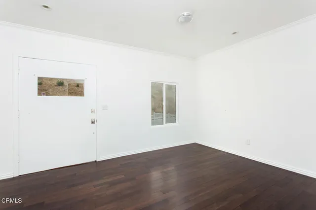 a view of a room with wooden floor and window