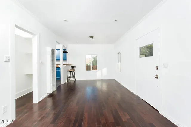 a view of a kitchen with wooden floor and a window
