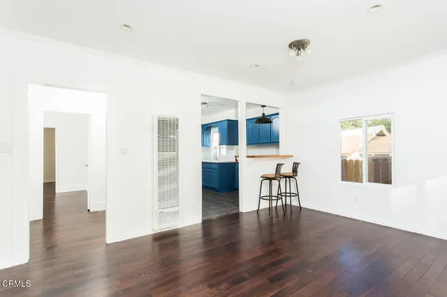 a view of a kitchen with furniture and wooden floor