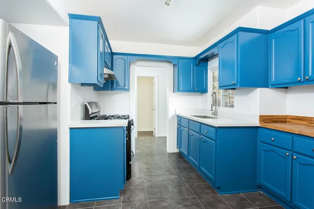 a kitchen with stainless steel appliances granite countertop a refrigerator a sink and wooden cabinets