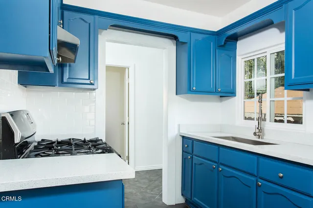 a kitchen with a sink a stove and cabinets