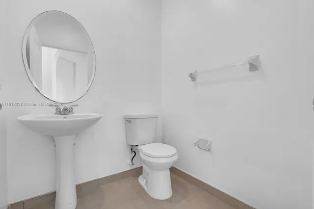 a bathroom with a sink toilet and a mirror