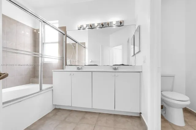 a bathroom with a granite countertop sink a toilet and shower