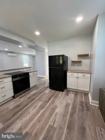 a view of kitchen with refrigerator and cabinets