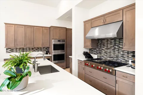 a kitchen with kitchen island granite countertop a sink stainless steel appliances and cabinets