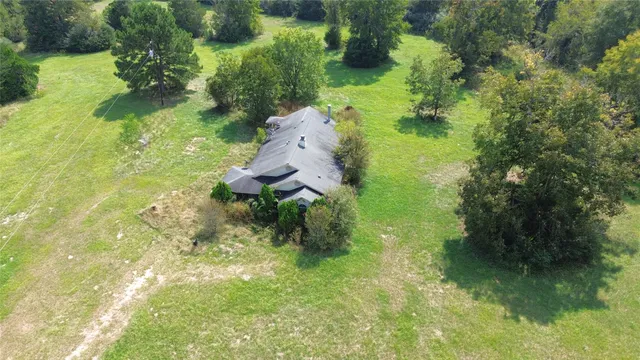 a backyard of a house with a yard and large trees