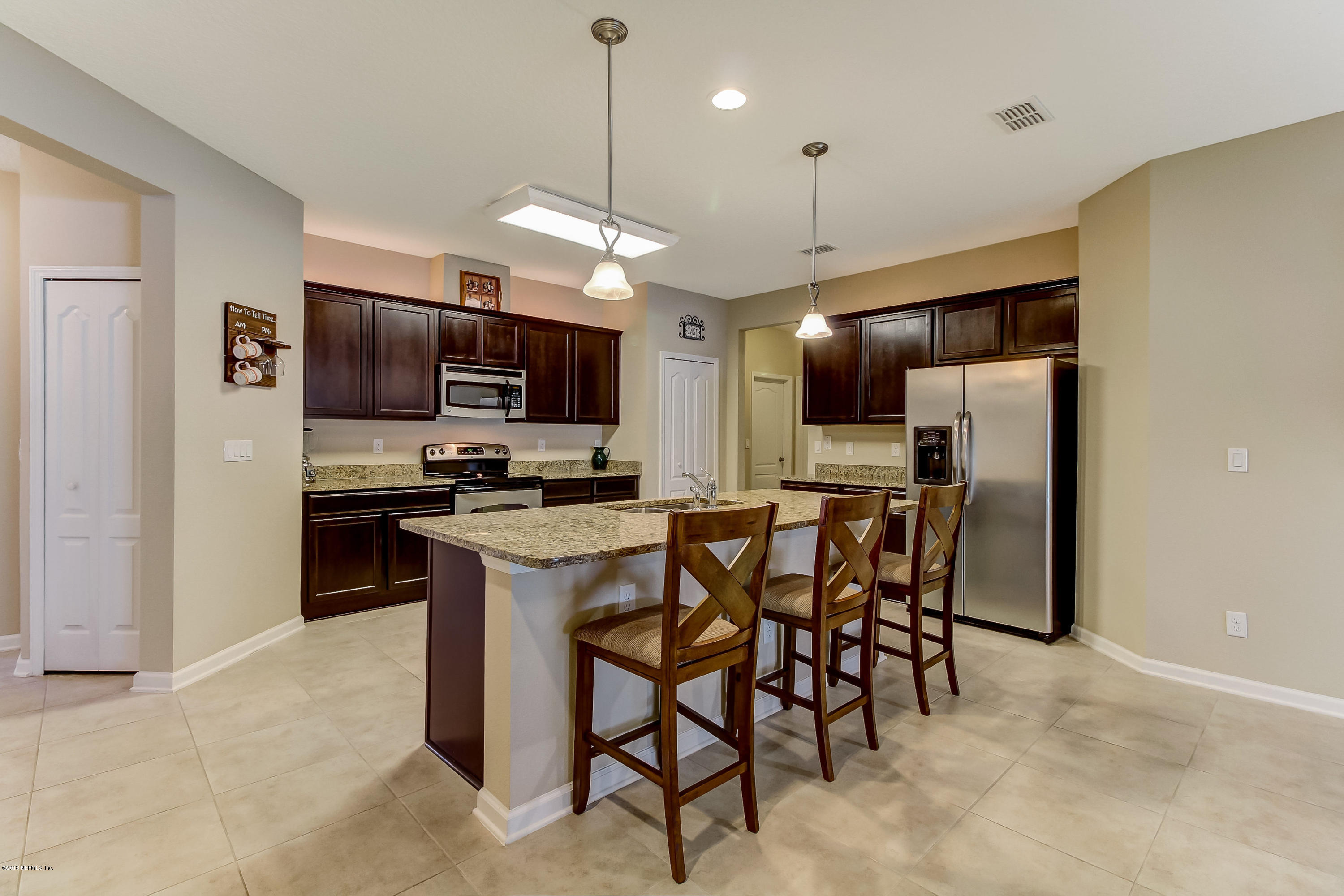 16480 Tisons Bluff Road Jacksonville, FL 32218 - Photo 17 of 80 a kitchen with stainless steel appliances kitchen island granite countertop a refrigerator a stove a microwave oven a sink with a dining table and chairs
