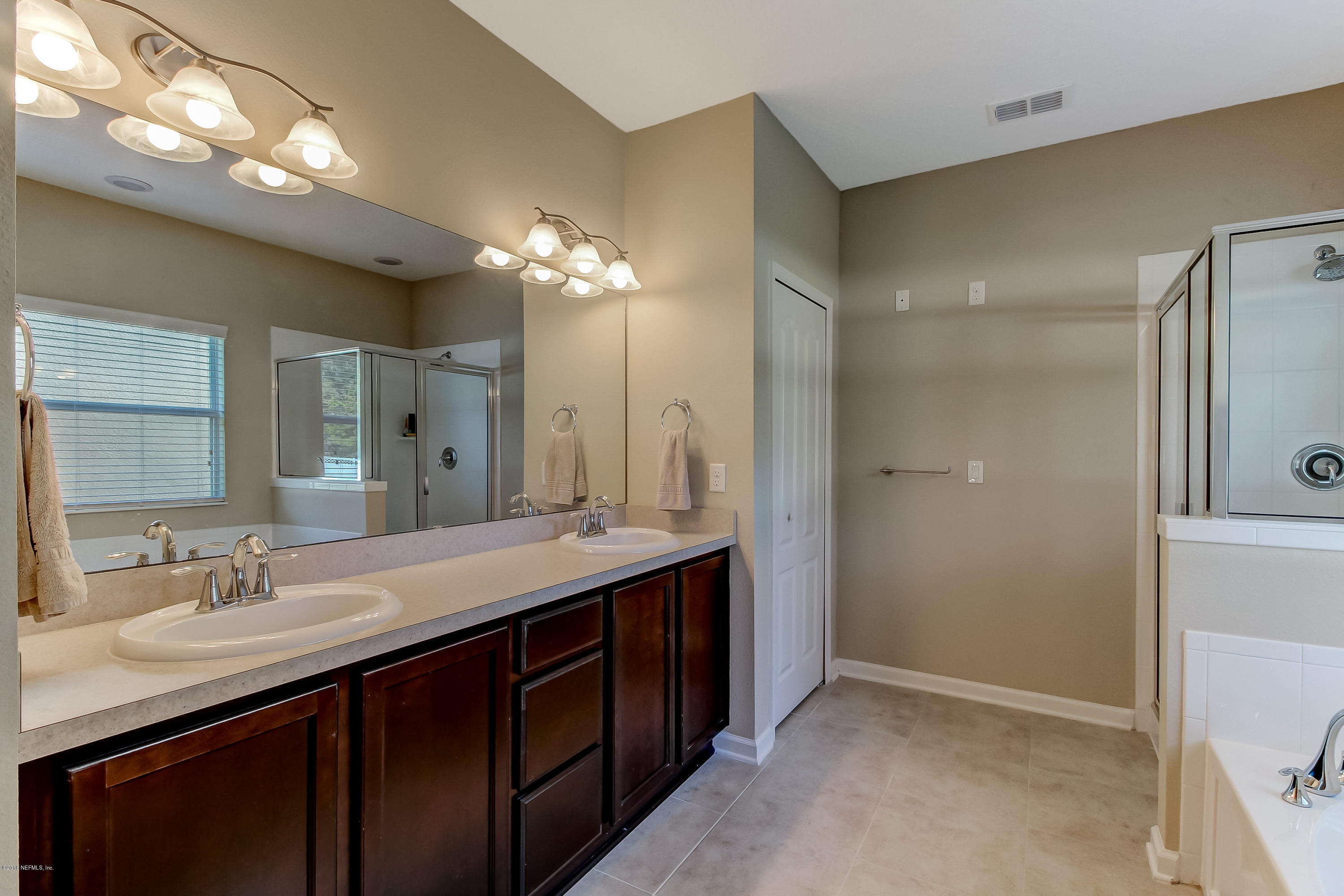 16480 Tisons Bluff Road Jacksonville, FL 32218 - Photo 33 of 80 a bathroom with a double vanity sink and a mirror