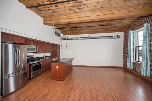 a kitchen with wooden floors and stainless steel appliances