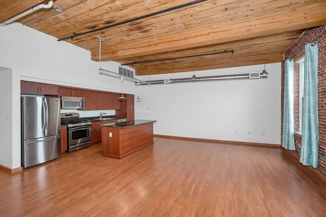 a view of a kitchen with wooden floor and stainless steel appliances
